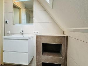 een badkamer met een wastafel en een open haard bij Beachvilla Grachtenkom in Makkum