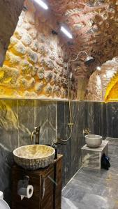 La salle de bains est pourvue de 2 lavabos et d'un mur en pierre. dans l'établissement karagül otel, à Şanlıurfa