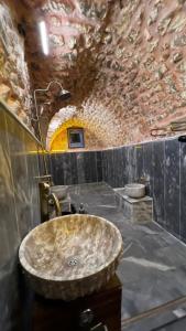 a bathroom with a sink and a stone wall at karagül otel in Urfa