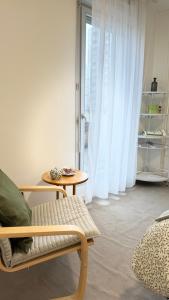 a room with a chair and a table and a window at Private room Serenity near Arena La Défense in Nanterre
