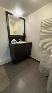 a bathroom with a sink and a mirror at Private room Serenity near Arena La Défense in Nanterre