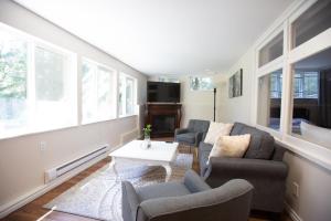 - un salon avec un canapé, des chaises et une table dans l'établissement Private Garden-Level Suite, à West Vancouver