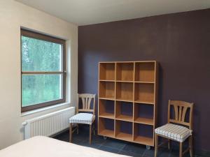 1 dormitorio con 2 sillas y estante para libros en Vakantiewoning Nieuwdonk, en Berlare