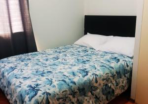 una camera da letto con un letto e un piumone floreale blu di Dpto Amoblado en San Miguel 2 a Lima
