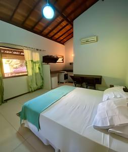 a bedroom with a large white bed in a room at Flat Oxóssi em condomínio beira-mar com varandão cozinha e piscina in Marau