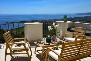 um pátio com uma mesa e cadeiras numa varanda em Paradisea Rocco's Villa em Taormina