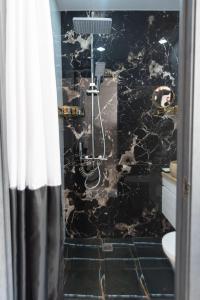 W łazience znajduje się prysznic ze ścianą z czarnego marmuru. w obiekcie Apartment in Old Tbilisi w mieście Tbilisi City +28 zdjęć