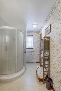 ein Bad mit einer ebenerdigen Dusche neben einer Wand in der Unterkunft Sunset Cottage 
