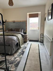 Un dormitorio con una cama y una ventana y una puerta. en Green Pasture, en Much Birch