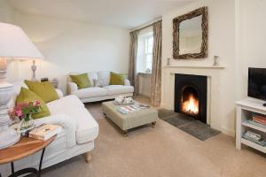 sala de estar con sofá blanco y chimenea en Garden Cottage, Teviot Bank, en Denholm