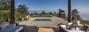 a patio with couches and a view of a pool at Dwarika's Resort - Dhulikhel in Dhulikhel