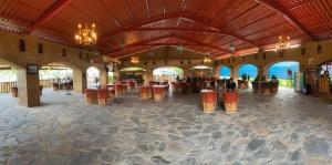 un vestíbulo con mesas y sillas en un edificio en Frutos Hotel en Ameca