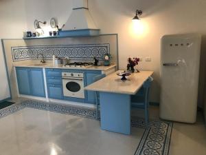 a kitchen with blue cabinets and a refrigerator at Blu Rooms Marettimo in Marettimo