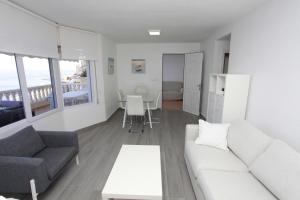 a living room with a white couch and a table at Villas Romanas with best sunsets and views in Cartagena