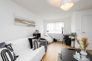 a living room with a white couch and a table at New Modern Luxury Cosy Home In Canterbury - Free Parking EV - Sleeps 7 in Sturry