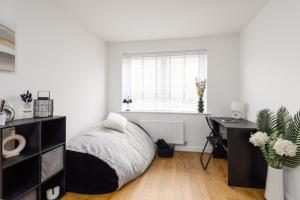 a bedroom with a bed and a desk and a window at Spacious Luxury House In Canterbury with Free Parking, Sleeps 7 in Canterbury