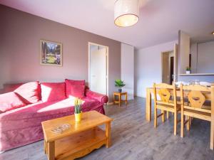 a living room with a red couch and a table at Appartement Peyragudes, 2 pièces, 6 personnes - FR-1-695-2 in Germ