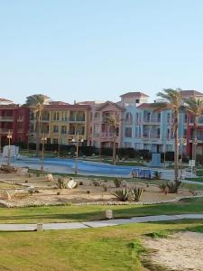 park z domami i basenem z palmami w obiekcie Porto Matroh ViP Spechial w mieście Marsa Matruh