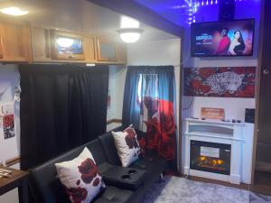 sala de estar con sofá, TV y chimenea en Romantic getaway en Decatur
