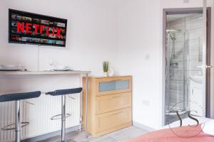 ein Badezimmer mit zwei Barhockern vor der Dusche in der Unterkunft Gorgeous Studio A - Wi-Fi Alton Towers Netflix in Stoke on Trent