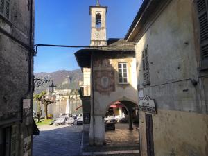 an old building with a clock tower on a street at Appartamento vacanze al lago Orta San Giulio in Orta San Giulio