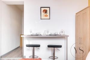 een kleine keuken met een bar met 2 krukken bij Gorgeous Studio B - Wi-Fi Alton Towers Netflix in Stoke on Trent