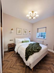 a bedroom with a large bed and a chandelier at Elevated Space Apartments, Shipston on Stour in Shipston on Stour