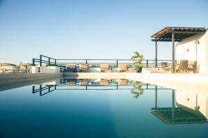 une piscine d'eau avec des chaises et une maison dans l'établissement Torre Diez Grupo Amber - Collection O, à Playa del Carmen
