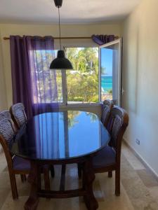 einen Esstisch mit Stühlen und ein großes Fenster in der Unterkunft Apartamento en la playa. in Punta Cana