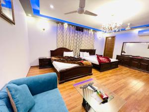 - un salon avec deux lits et un canapé dans l'établissement Imperial Lodges, à Islamabad