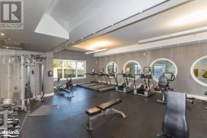 a gym with several treadmills and machines in it at Large Luxury Waterfront Penthouse in Collingwood