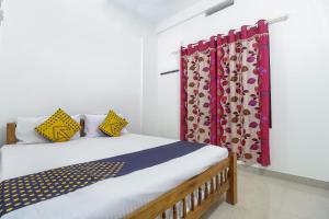a bedroom with a bed with colorful curtains at SPOT ON Rohini Inn Kadampuzha in Kottakkal