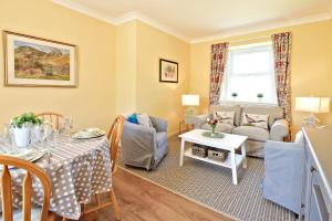 a living room with a table and a couch at Fordel Cottage in Dalkeith