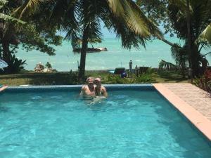 un hombre y una mujer en una piscina con vistas al océano en Mermaid Manor Belize en White Hill