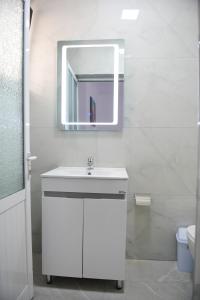 La salle de bains est pourvue d'un lavabo blanc et d'un miroir. dans l'établissement Hotel Villa Edis, à Berat
