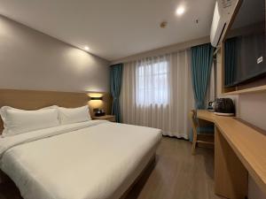 um quarto de hotel com uma cama grande e uma secretária em Pod Hotel - Guangzhou Luoxi Subway Station Canton Tower em Guangzhou