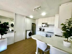 a kitchen with white cabinets and a table and chairs at Departamento galáctico con vista al desierto in Calama