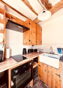 eine Küche mit Holzschränken, einem Herd und einer Spüle in der Unterkunft The Hideout in Linton