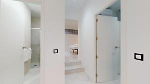 un pasillo con paredes blancas y una puerta de cristal en Agd Living 1, en Algarrobo Costa