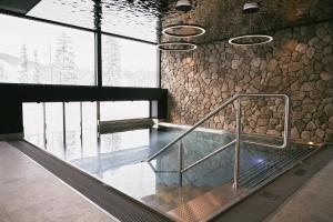 an elevator in a building with a stone wall at TRIFORÊT alpinresort in Hinterstoder