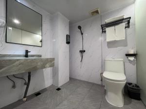 uma casa de banho com um lavatório, um WC e um espelho. em Pod Hotel - Guangzhou Luoxi Subway Station Canton Tower em Guangzhou