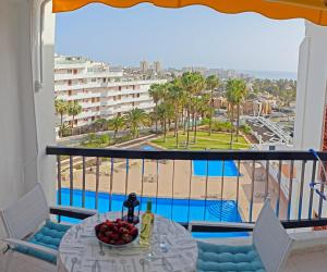 a balcony with a table and a view of a pool at Blanco&Azul - Ocean View Balcony, Pool and Perfect Location in Playa de las Americas