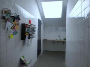 a hallway of a bathroom with a sink and a window at Caravan Vlinder in Rouveen
