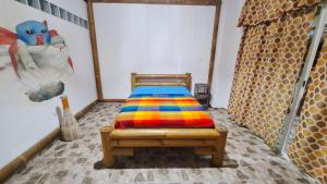 Un dormitorio con una cama con una manta de colores. en Casa Gaia Paradise en Mompiche