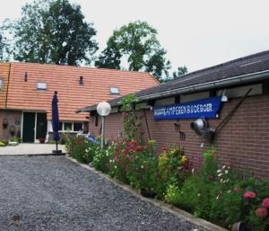 a building with a sign on the side of it at Caravan Vlinder in Rouveen