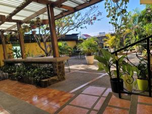 un patio al aire libre con pérgola y plantas en Pura Vida Dream en San José