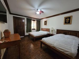 a bedroom with two beds and a ceiling fan at Pura Vida Dream in San José