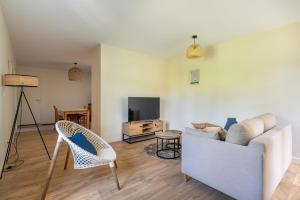 TV a/nebo společenská místnost v ubytování Pépoule - Appartements avec vue sur les monts du Beaujolais