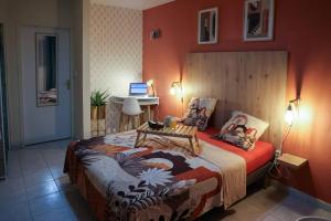 a bedroom with a large bed with a laptop on it at Grand studio Bis à Matoury in Matoury