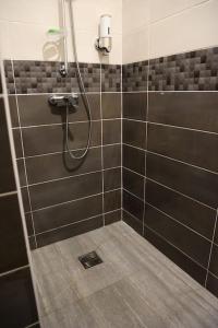 a bathroom with a shower with black and gray tiles at Grand studio Bis à Matoury in Matoury